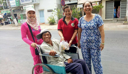 Chị Loan (người đứng giữa) đem trao những phần thức ăn đến tận tay người khuyết tật