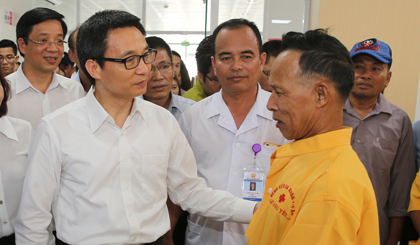 Phó Thủ tướng Vũ Đức Đam trò chuyện với người nhà bệnh nhân tại Bệnh viện đa khoa thị xã Quảng Yên, Quảng Ninh. Ảnh: VGP/Đình Nam