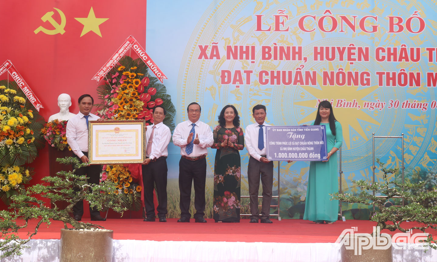 Đồng chí Nguyễn Thị Sáng và đồng chí Phạm Anh Tuấn trao Bằng công nhận và Bảng tượng trưng công trình phúc lợi trị giá 1 tỷ đồng cho lãnh đạo xã Nhị Bình.