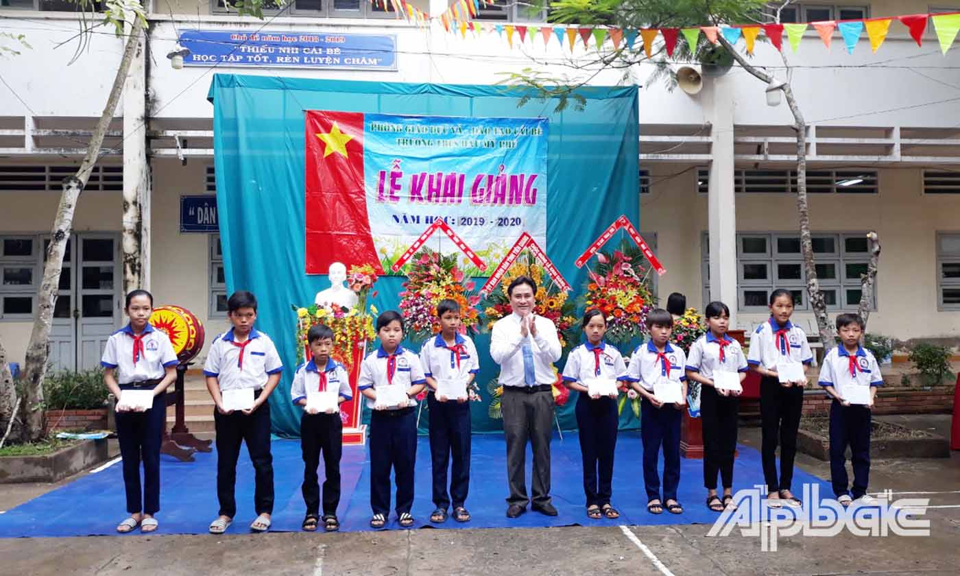 Đồng chí Trần Văn Dũng trao học bổng cho các em học sinh vượt khó học tốt của Trường THCS Hậu Mỹ Phú.
