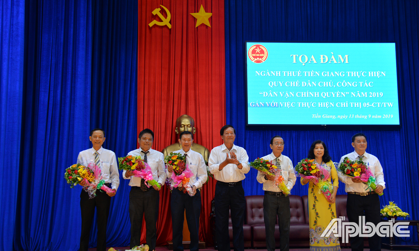 Đồng chí Nguyễn T6an1 Lộc, Cục trưởng Cục Thuế Tiền Giang tặng hoa cho các đại biểu tham gia tọa đàm
