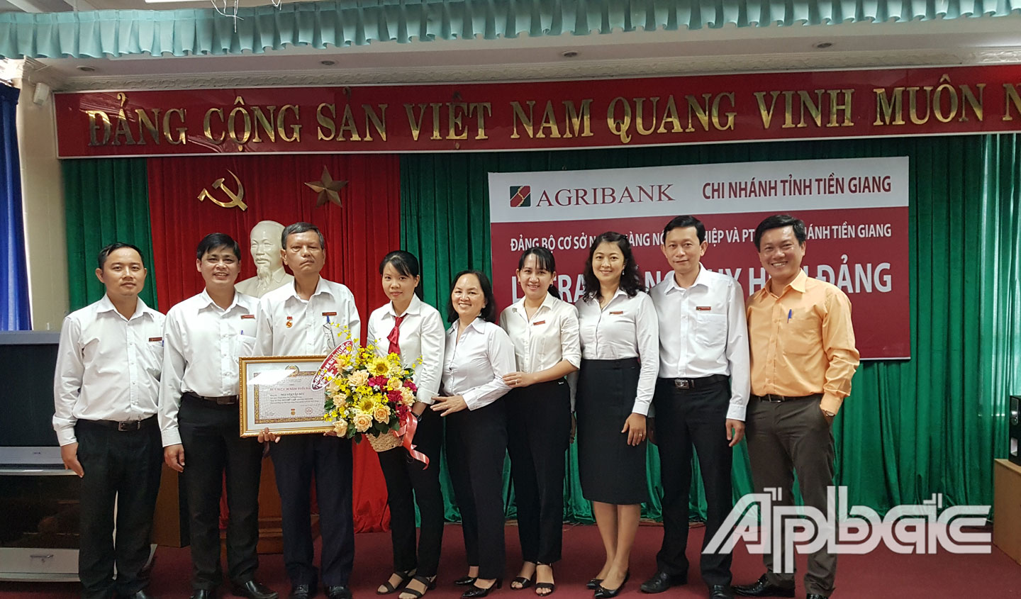 Đồng chí Nguyễn Văn Huỳnh – Bí thư Đảng bộ – trao huy hiệu cho đồng chí Nguyễn Văn Đức