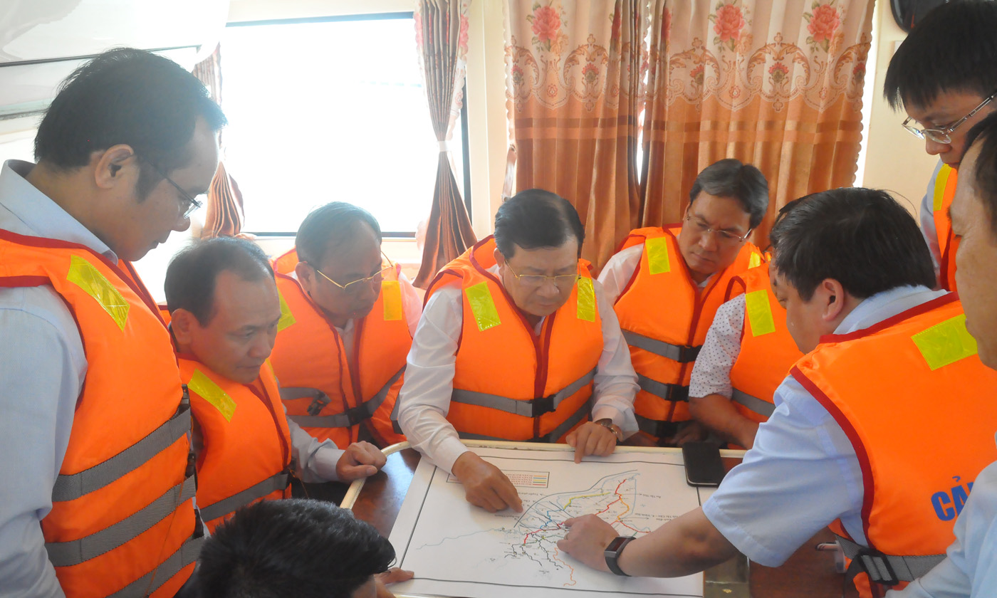 Phó Thủ tướng Chính phủ (giữa) nghe các đơn vị chức năng liên quan thuyết minh về Dự án nâng cấp tuyến kênh Chợ Gạo.