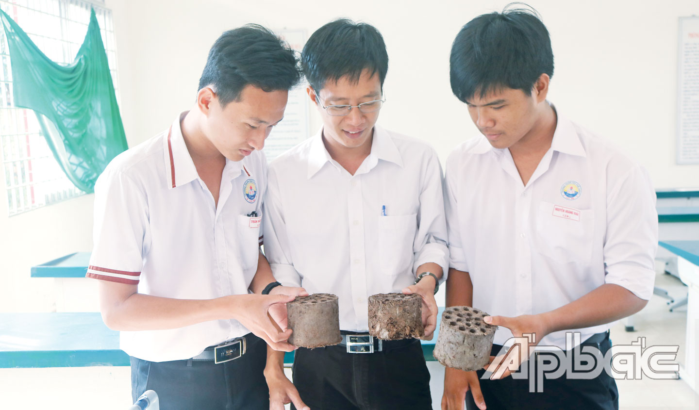 Thầy Huỳnh Minh Huy (giữa) và các học sinh trong Nhóm nghiên cứu  cầm trên tay sản phẩm than tổ ong làm từ vỏ sầu riêng.