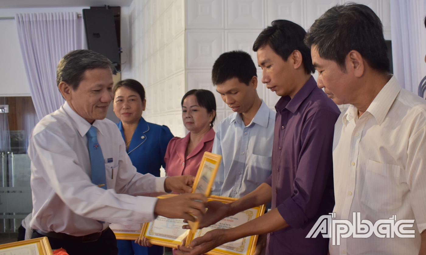 Phó Giám đốc Công ty Điện lực Tiền Giang Nguyễn Trung Trí trao giấy công nhận gia đình tiết kiệm điện năm 2019.
