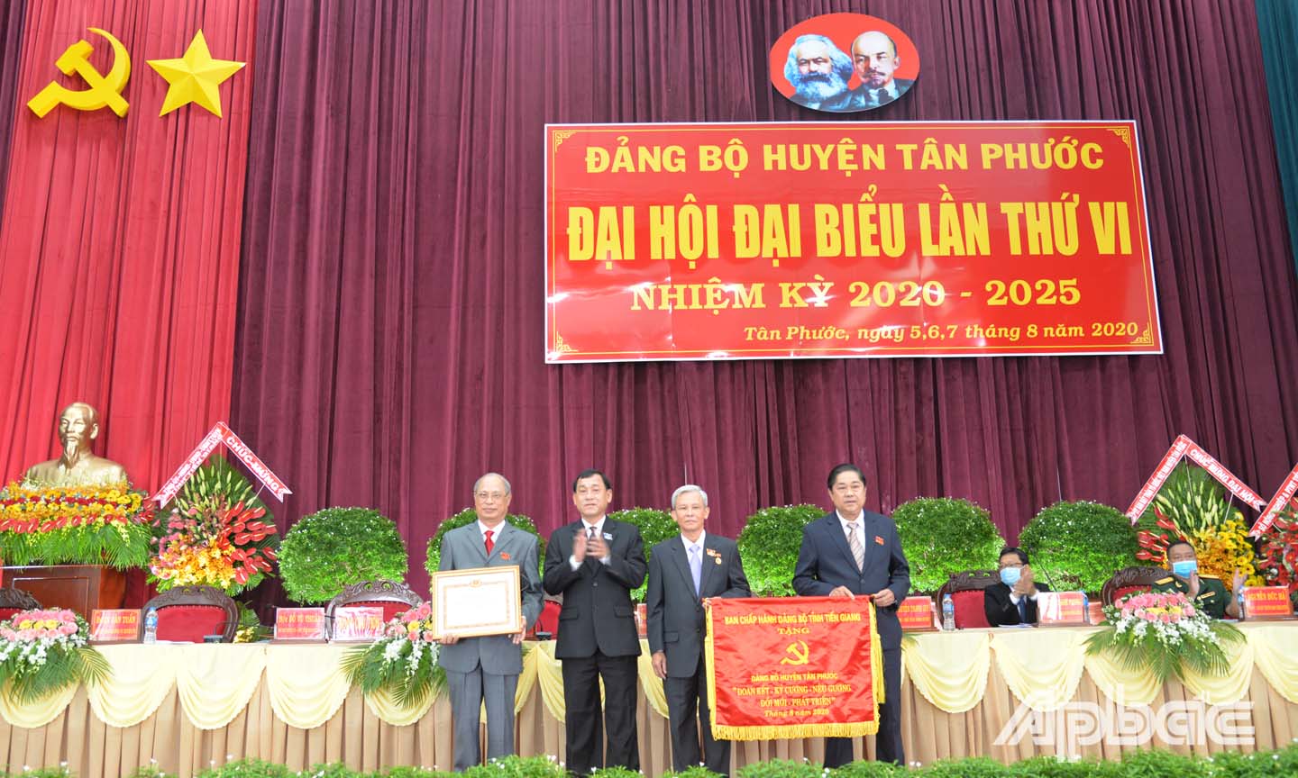 Đồng chí Nguyễn Văn Vĩnh (thứ hai từ bên trái) trao Bằng khen của Ban Thường vụ Tỉnh ủy và Bức trướng của Ban Chấp hành Đảng bộ tỉnh đến Ban Chấp hành Đảng bộ huyện Tân Phước tại Đại hội.