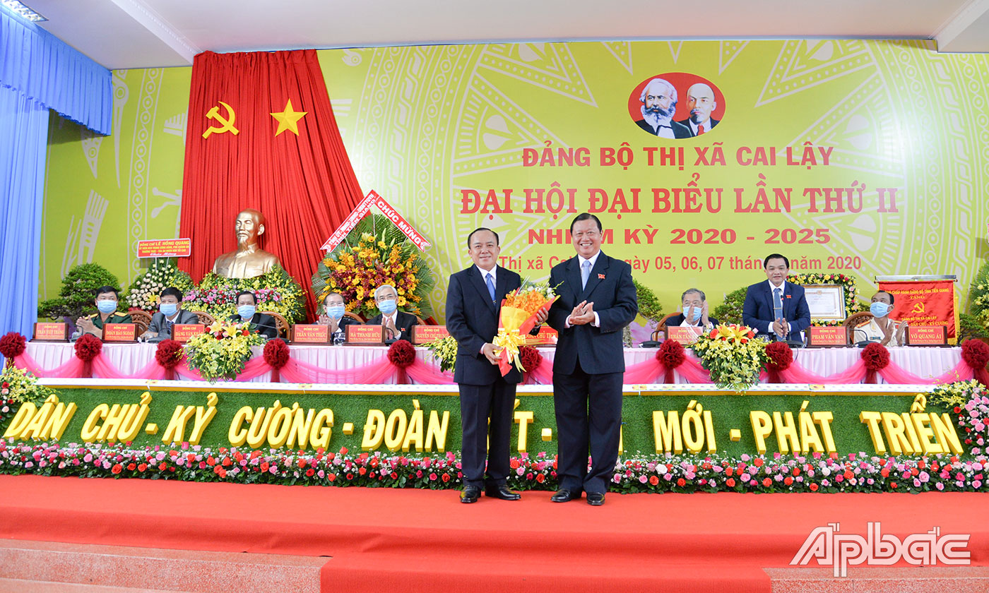 Đồng chí Phan Phùng Phú, Tỉnh ủy viên, Bí thư Thị ủy Cai Lậy tặng hoa cảm ơn đồng chí Nguyễn Chí Trung.