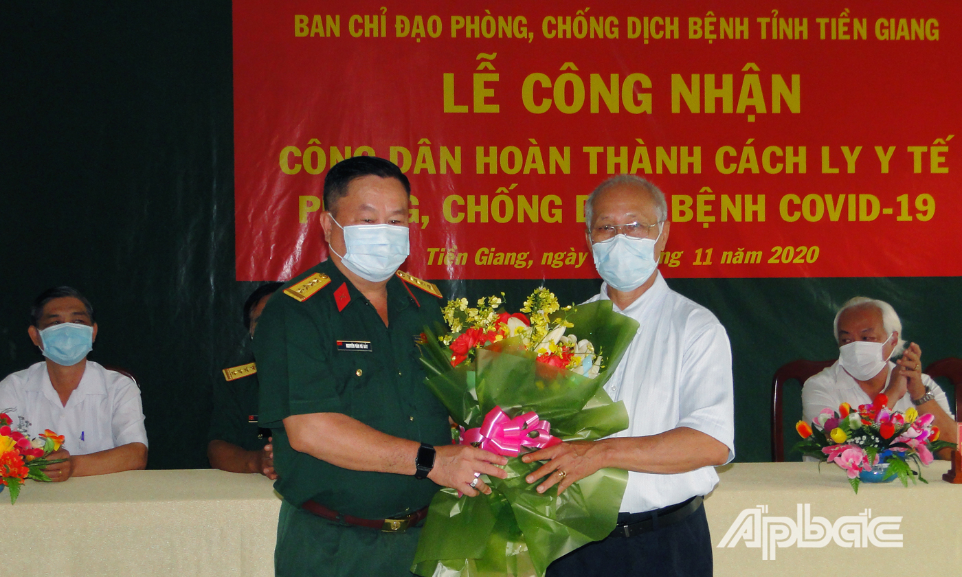 Đồng chí Nguyễn Văn Bé Bảy, Phó Chỉ huy trưởng Bộ chỉ huy quân sự tỉnh Tiền Giang trao hoa chúc mừng công dân