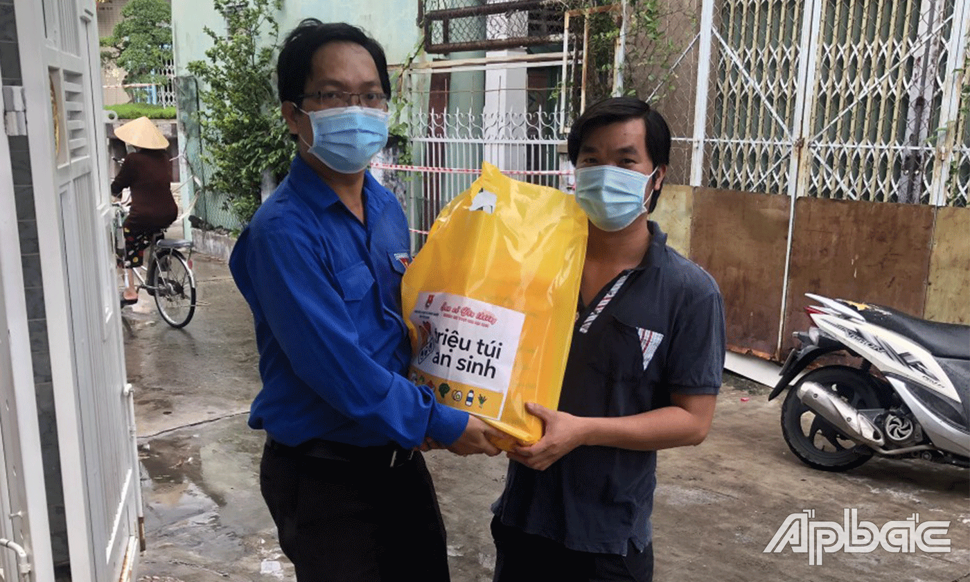 Bí thư đoàn khối Nguyễn Xuân Phúc tận tay chuẩn bị và trao các túi quà an sinh cho người dân.