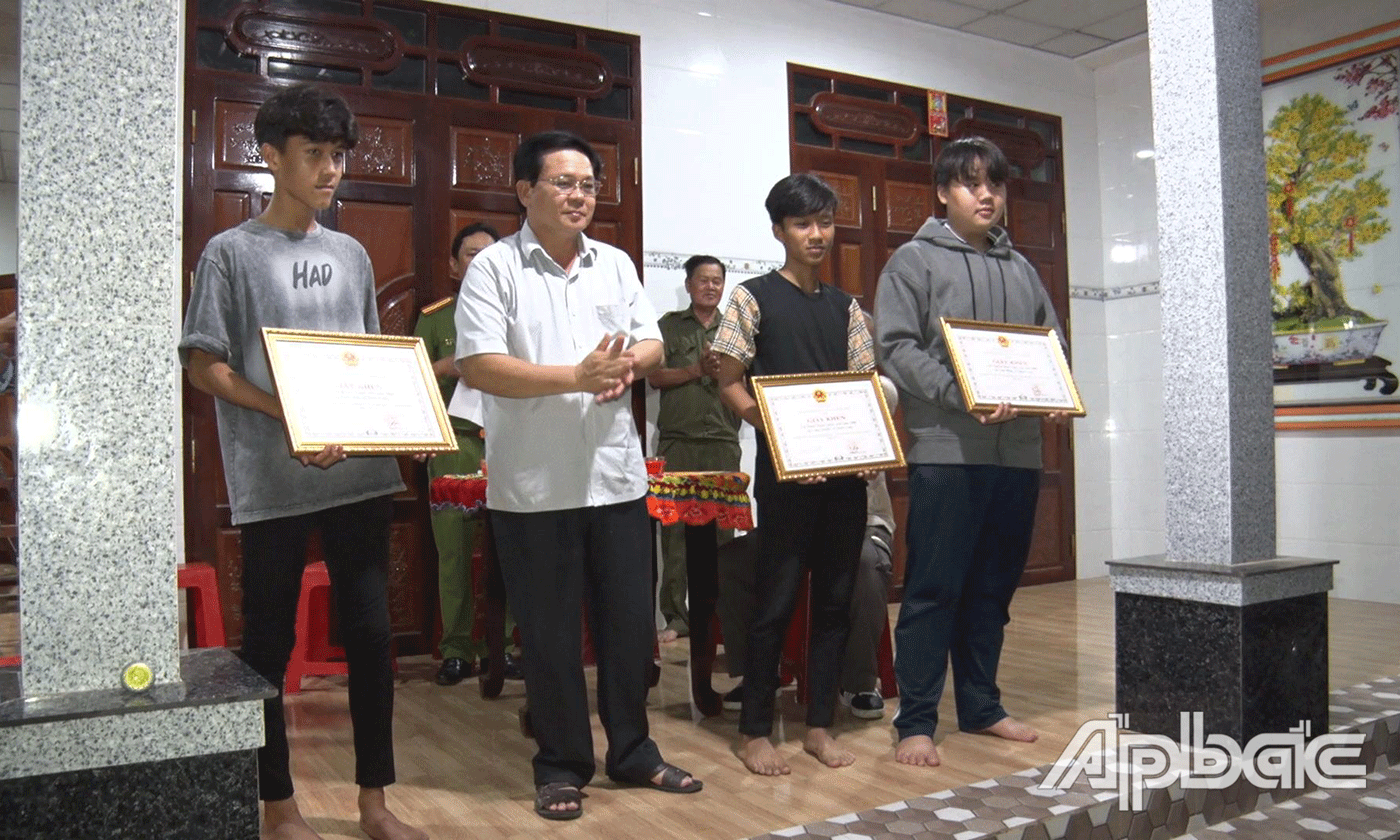 Bí thư, Chủ tịch UBND xã Qươn Long Phan Hoàng Định trao giấy khen cho 3 cá nhân.