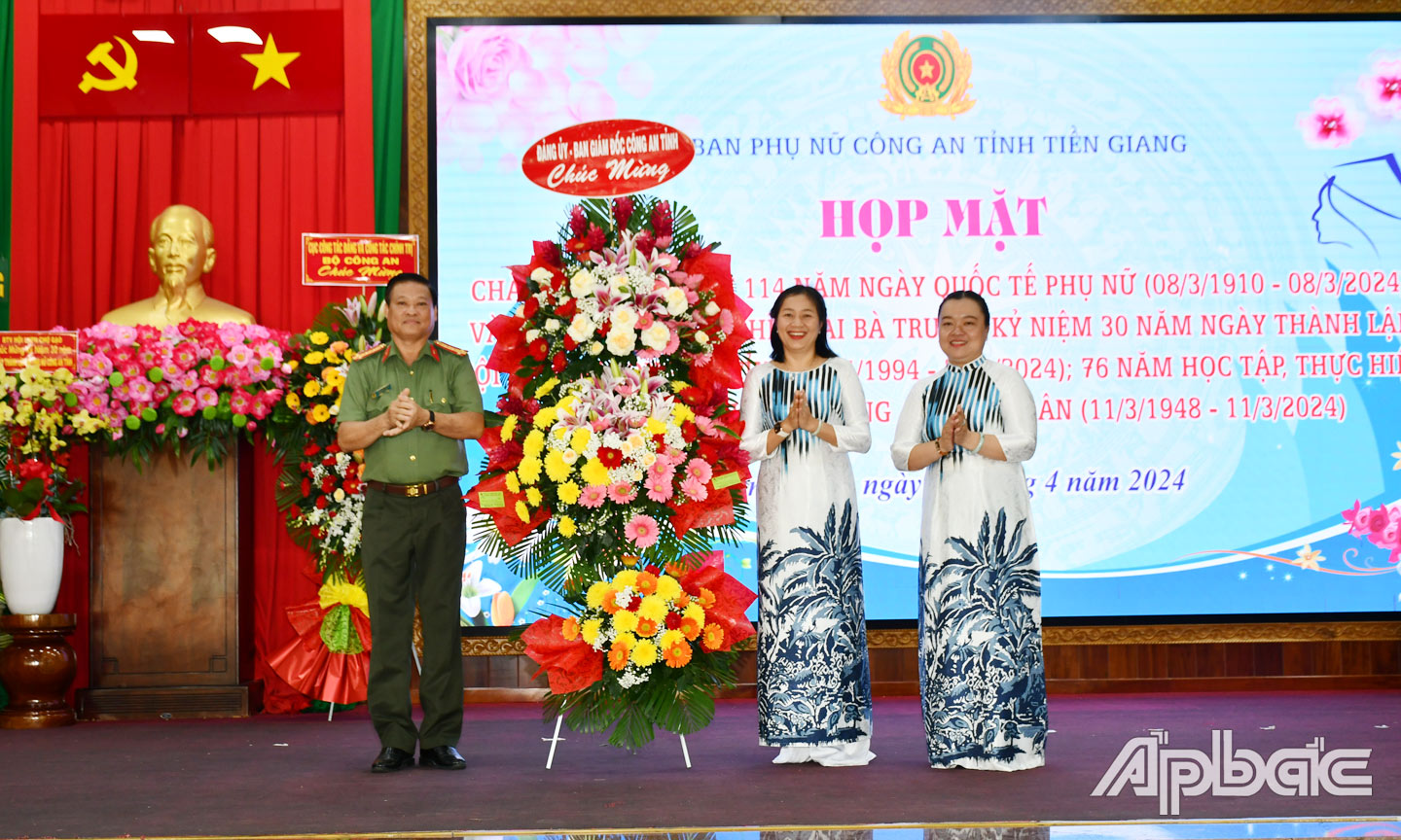 Đại tá Phan Văn Trảng, Phó Giám đốc Công an tỉnh tặng hoa chúc mừng họp mặt. Ảnh TRỌNG TÍN.