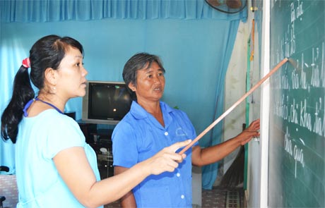 Chị Lê Thị Tuyết Thanh cặm cụi cầm tay đối tượng để giúp họ nắn nót viết từng con chữ.