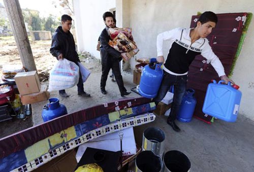 Người tị nạn Syria nhận hàng viện trợ từ UNHCR. Ảnh: Reuters