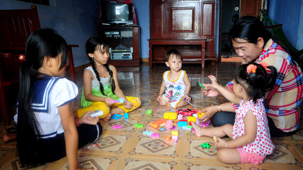 Chị Thúy giúp trông những đưa trẻ của các hộ dân ở thị trấn.