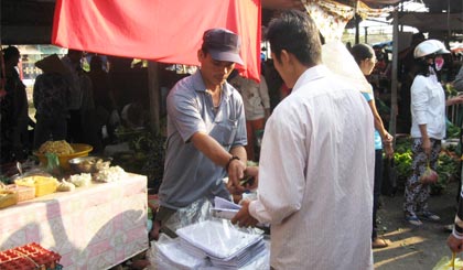 Một người  đàn ông  bán sách  bói toán, tử vi  tại chợ thị trấn Vĩnh Bình  vào sáng 27-1. 