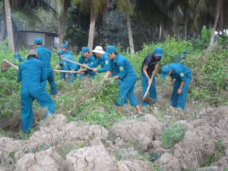 Dân quân tham gia làm công tác quần chúng phát quang bụi rậm.