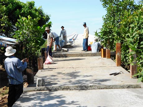 Người dân ấp Tân Bường A góp sức thi công cầu cồn Bầu.        Ảnh: NGUYỄN BẢY)