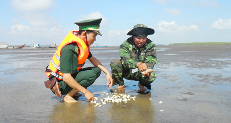 Ông Nguyễn văn Ron (phải) đang trao đổi kỹ thuật nuôi nghêu. 