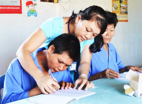 Chị Lê Thị Tuyết Thanh chăm sóc người khuyết tật tại Trung tâm Công tác xã hội. Ảnh: Trọng Tấn