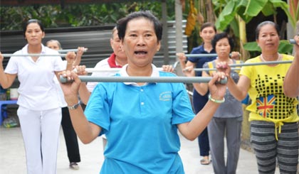 Cô Tư hướng dẫn tập luyện dưỡng sinh cho bà con trong ấp để giúp mọi người nâng cao sức khỏe.