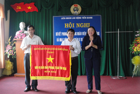 Bà  Trần Kim Mai, Phó Chủ tịch UBND tỉnh  trao Cờ thi đua của Chính phủ cho LĐLĐ tỉnh.