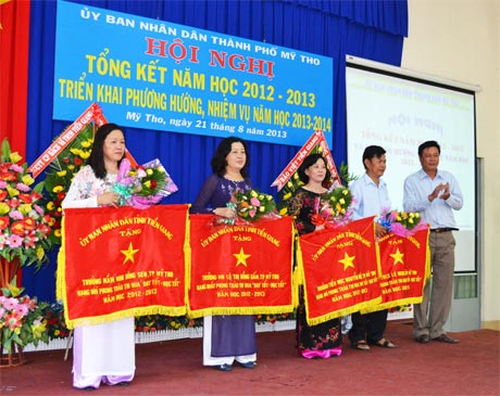 Ông  Nguyễn  Trọng Hữu,  Trưởng Ban Tuyên giáo  Thành ủy  Mỹ Tho  trao cờ  và tặng hoa  cho 4 đơn vị  đạt thành tích  xuất sắc  trong năm học 2012-2013.