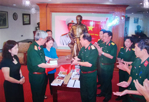 Trung tướng Mai Quang Phấn, Phó chủ nhiệm Tổng cục Chính trị trao tặng một số hiện vật cho gia đình Đại tướng Nguyễn Chí Thanh (10-2013).