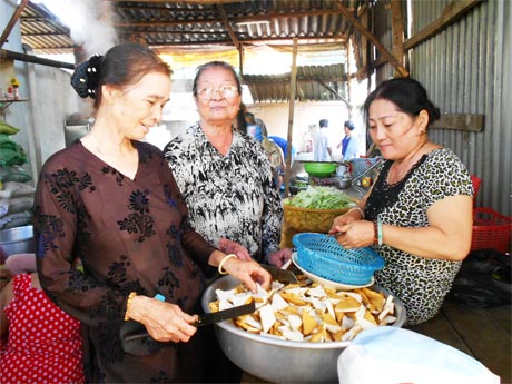 Bà Huỳnh Kim Lang (giữa) cùng các thành viên  Tổ Từ thiện 19-5 chuẩn bị bữa cơm miễn phí cho bệnh nhân.