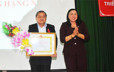 Bà Trần Kim Mai, Phó Chủ tịch Thường trực UBND tỉnh Tiền Giang, thừa ủy quyền của Chủ tịch nước trao Huân chương Lao động hạng Nhất cho PGS. TS Nguyễn Minh Châu.  Ảnh: HT