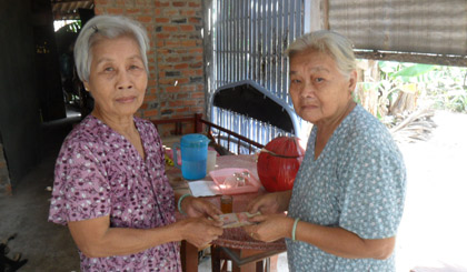 đại diện chùa Nhơn Phước trao tiền cho bà Tỏ- bà tỏ mặc áo xanh.
