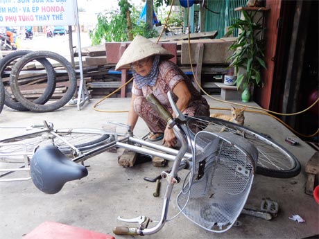 Cô Tư  đang  sửa xe  cho khách.