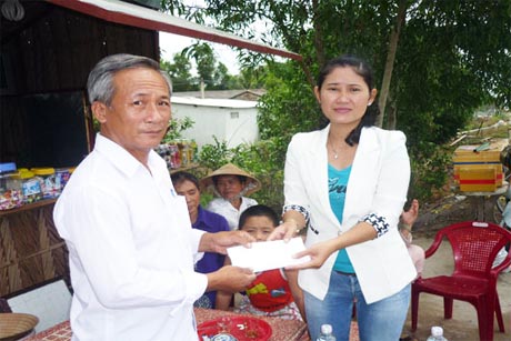 Ông Trần Thành Nhân, Trưởng ấp 5  nhận tiền để mua tập  tặng học sinh nghèo trong ấp. 