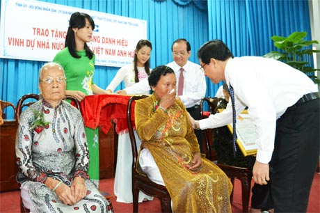 Mẹ Giảng Thị Gấm đã rơi nước mắt khi đón nhận danh hiệu vinh dự Nhà nước Bà mẹ VNAH từ tay ông Lê Hồng Quang, Phó Bí thư Tỉnh ủy.