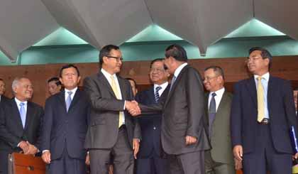 Thủ tướng Hun Sen và Chủ tịch CNRP Sam Rainsy bắt tay tuyên bố về thỏa thuận giải quyết bế tắc chính trị vừa đạt được. (Ảnh: Trần Chí Hùng/TTXVN)