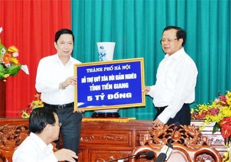 Ủy viên Bộ Chính trị, Bí thư Thành ủy TP. Hà Nội Phạm Quang Nghị trao ngân phiếu tượng trưng cho Bí thư Tỉnh ủy Tiền Giang Trần Thế Ngọc.