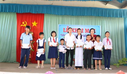 Bà Trần Thị Quý Mão, Phó Giám đốc Sở Giáo dục và Đào tạo trao học bổng và quà cho các học sinh vượt khó học giỏi  huyện Chợ Gạo.