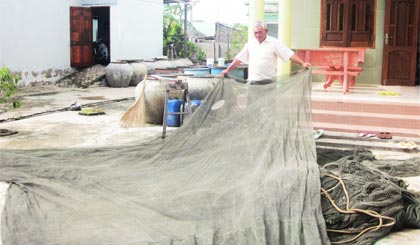 Ông Trần Xảm đang phơi lưới sau chuyến ra khơi về.