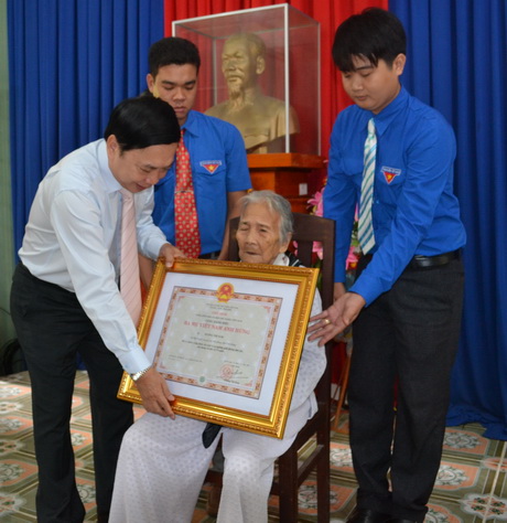 Ông Trần Thế Ngọc, Bí thư Tỉnh ủy gắn Huy hiệu và trao Bằng Danh hiệu vinh dự Nhà nước “Bà mẹ Việt Nam Anh hùng” cho mẹ Dương Thị Năm, xã Phú Thạnh. 