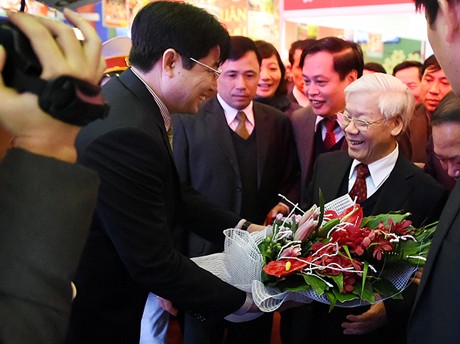 Phó Chủ nhiệm VPCP Nguyễn Văn Tùng tặng hoa Tổng Bí thư Nguyễn Phú Trọng tại gian trưng bày của Cổng TTĐT Chính phủ, Báo Điện tử Chính phủ. Ảnh: Quang Hiếu