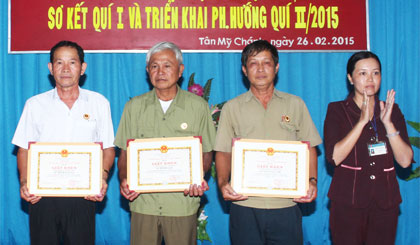 Bà Nguyễn Thị Hoàng Anh, Phó Bí thư Đảng ủy xã trao Giấy khen cho các tập thể thực hiện tốt Chỉ thị 03 của Bộ Chính trị. Ảnh: N. TRUNG