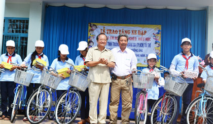 Ông Trần Thanh Đức, Phó Chủ tịch UBND tỉnh và đại diện Công ty TNHH Thương mại Tân Hoàng Gia (TP. Hồ Chí Minh) trao quà cho các em.