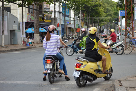 Khi đèn tín hiệu chuyển màu đỏ, xe máy dừng đỗ chèn lên vạch sơn dành cho người đi bộ sang đường và tranh  thủ quẹo phải để vượt đèn đỏ tại ngã tư Nguyễn Trãi và Lê Lợi.