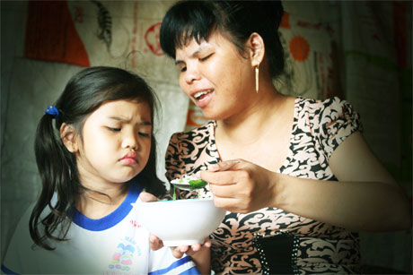 Yến Vi nũng nịu xin mẹ để tự múc cơm ăn.
