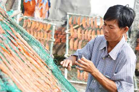 Người dân đan lưới để phơi các loại khô.