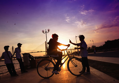 Các em học sinh Trường Tiểu học Nguyễn Huệ vui đùa với nhau trong ráng hoàng hôn.