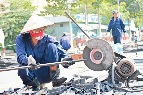 Giữa cái nắng ban trưa, cùng với nhiệt độ nóng bức của mặt đường nhựa,  công nhân vẫn miệt mài thi công Đường hoa Hùng Vương.