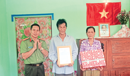 Đại tá Nguyễn Văn Ngươn, Trưởng phòng Công tác Chính trị - Công an tỉnh trao Quyết định của Giám đốc Công an tỉnh về việc cấp nhà đồng đội  và trao quà tặng ông Trần Văn Lời.