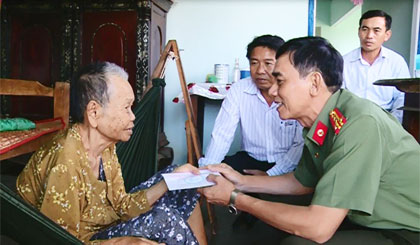 Đại tá Nguyễn Hữu Trí, Ủy viên Ban Thường vụ Tỉnh ủy, Giám đốc Công an tỉnh thăm, tặng quà Bà mẹ Việt Nam Anh hùng Huỳnh Thị Lệ, ngụ xã Phú Đông, huyện Tân Phú Đông. Ảnh: Trọng Tín