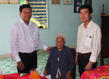 Ông Phan Văn Hoàng (trái), Phó Chủ tịch UBND thành phố chúc sức khỏe, tặng quà cụ bà Nguyễn Thị Chính, là mẹ liệt sĩ, ngụ  ấp 3B, xã Đạo Thạnh. 