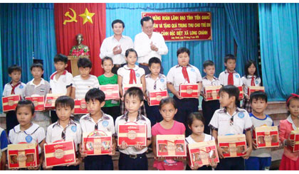  Ông Lê Văn Nghĩa, Phó Chủ tịch UBND tỉnh (bên phải) tặng quà trung thu cho các em có hoàn cảnh khó khăn xã Long Chánh, TX. Gò Công.